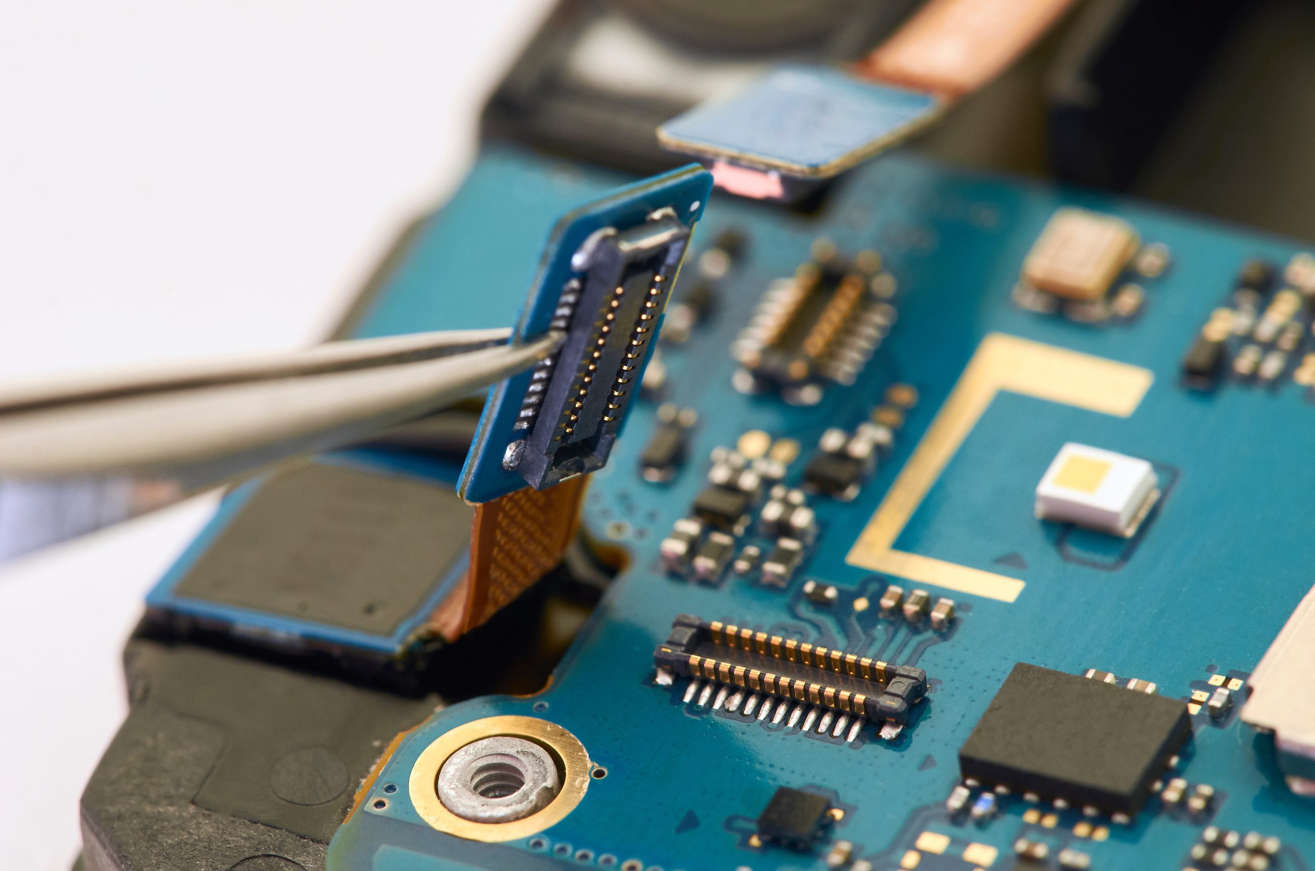 Disassembly of smartphone showing electrical board inside. The phone is fixing.